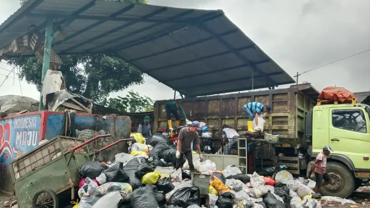 Petugas pengangkut sampah di tengah tumpukan sampah yang menggunung. Volume sampah harian di kawasan ini dilap