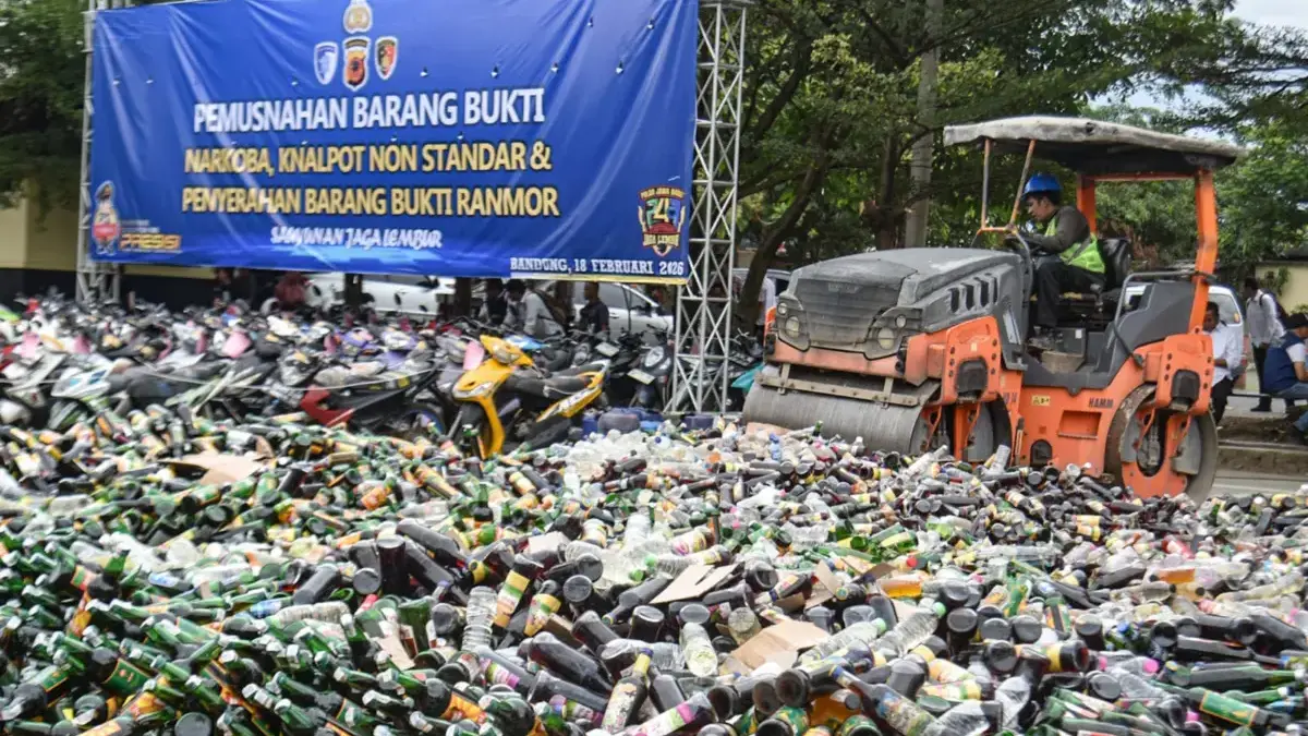 Berantas Narkotika, Ratusan Ribu Obat Terlarang hingga Miras di Bandung DImusnahkan! Petugas mengoperasikan alat berat untuk memusnahkan minuman keras di Polda Jabar, Kota Bandung Rabu (18/2). Po