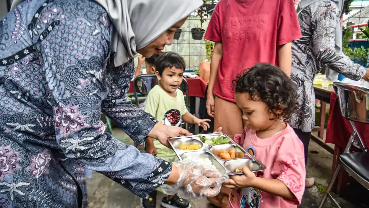 Kader Pemberdayaan dan Kesejahteraan Keluarga membagikan paket Makan Bergizi Gratis (MBG) kepada balita di bal