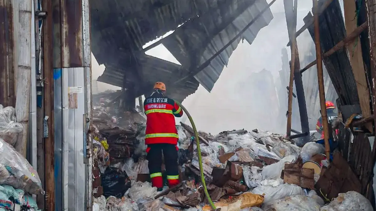 Diduga Korsleting Listrik, Gudang Rongsok di Ngamprah Terbakar Petugas pemadam kebakaran saat berupaya memadamkan kobaran api yang menghanguskan gudang rongsok
