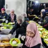 Relawan dari Masjid Makan-Makan membagikan hidangan gratis untuk berbuka puasa kepada jamaah di pelataran Masj