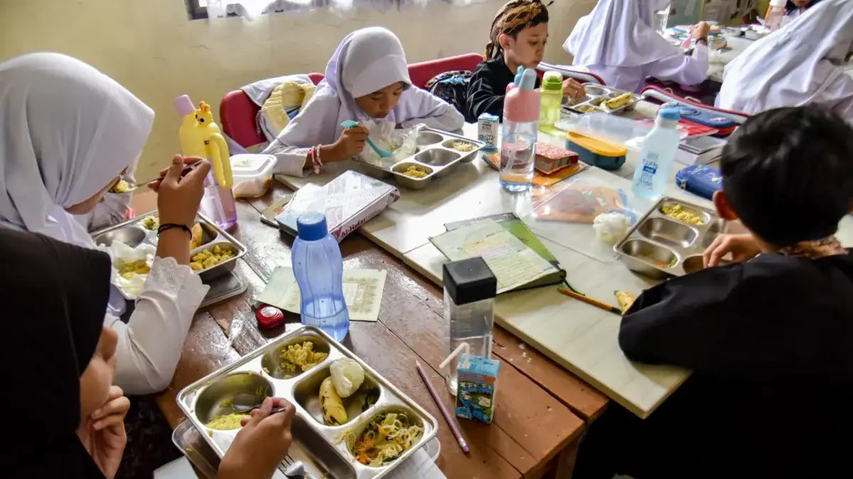 Ilustrasi: Pelajar SD sedang menyantap menu MBG saat di sekolah sebelum bulan Ramadan. Foto: Dimas Rachmatsyah