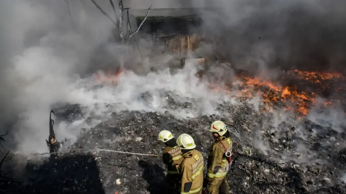 Petugas pemadam kebakaran berusaha memadamkan api yang membakar gudang di Gang Kurdi, Cibolerang, Kecamatan Ba