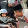 Kapolres Ciamis AKBP Hidayatullah menyapa anak kecil saat membagikan takjil kepada pengendara bermotor di dep