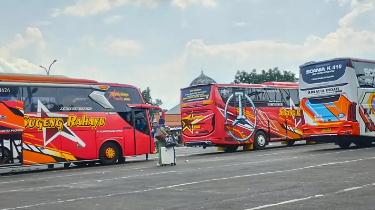 Arus Balik Terminal Cicaheum Mulai Bergerak, 836 Penumpang Tiba di Bandung Pemudik melintas di antara bus yang menunggu keberangkatan di Terminal Cicaheum, Kota Bandung, Jawa Barat, Sel