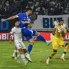 Pemain Persib Bandung Julio Cesar (tengah) menendang bola dan dihalau penjaga gawang Arema FC Lucas Henrique F