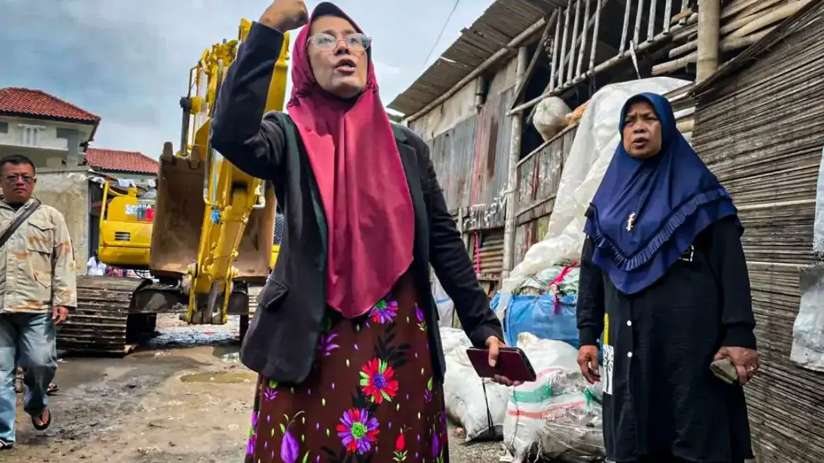 Seorang ibu rumah tangga menghadang alat berat yang akan merobohkan bangunan miliknya di kawasan Situ Ciburuy,