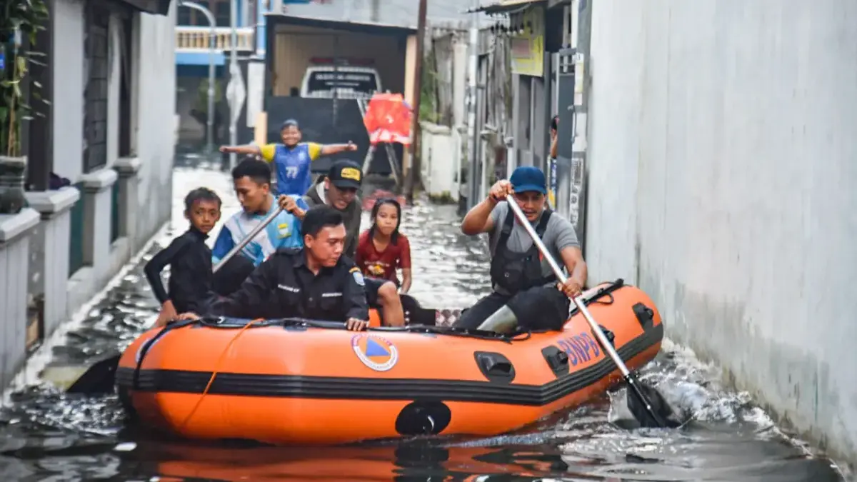 Petugas menggunakan perahu menyusuri banjir di Jalan Derwati, Kelurahan Rancabolang, Kecamatan Gedebage
