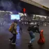 Pengunjuk rasa mendorong pembatas jalan saat berlangsungnya unjuk rasa pada Hari Buruh di simpang Jalan Cikapa