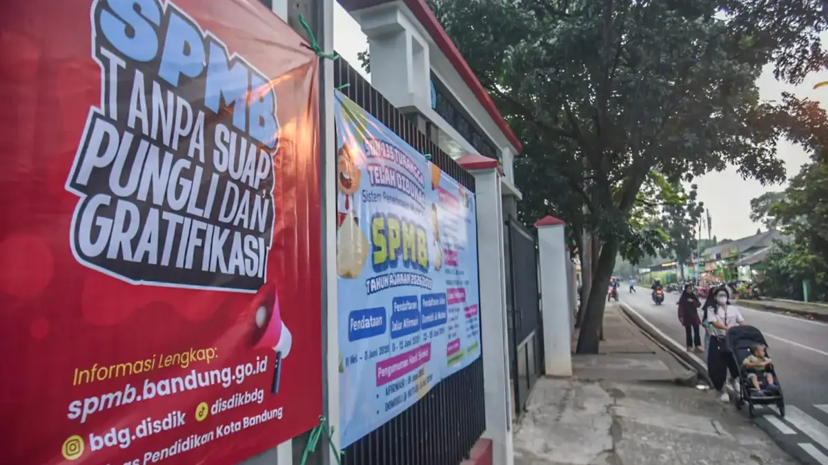 SPMB 2026 Kota Bandung Diawasi Ketat, Pemkot Ingatkan Warga Tolak Titip Kursi hingga Pungli Warga berjalan melintas spanduk informasi sistem penerimaan murid baru (SPMB) tanpa pungutan liar ataupun grat