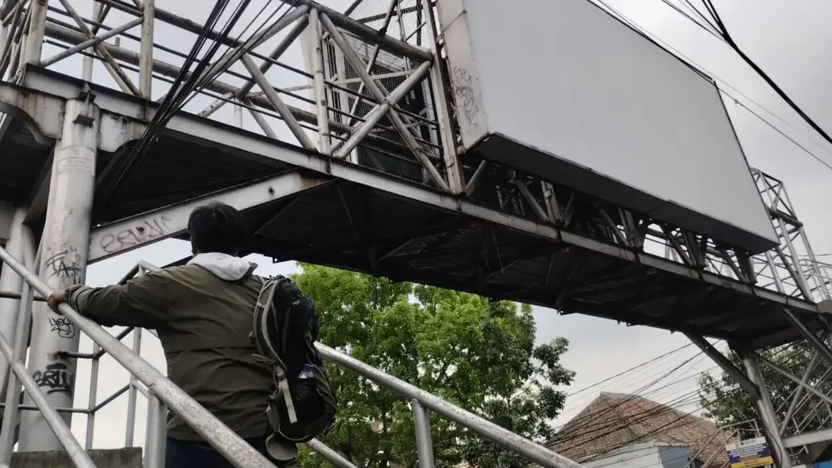Satpol PP Bandung Gencarkan Penertiban Reklame di 17 Jalur Utama, Baru 3 Titik Ditindak Ilustrasi: Seorang warga berjalan di samping papan reklame di Jalan Gatot Subroto, Kota Bandung, Jumat (15/5)