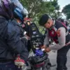 Petugas kepolisian saat mengecek barang bawaan suporter sebelum memasuki area stadion GBLA. Foto. Dimas Jabar