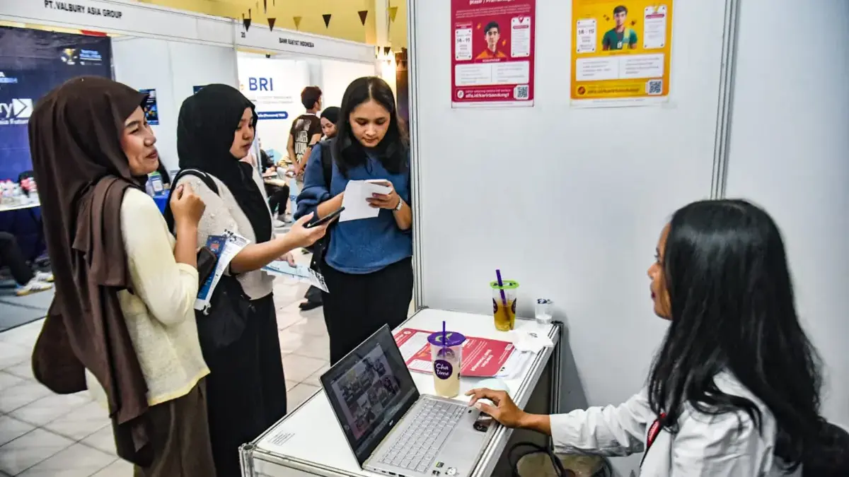 Pencari kerja mencari informasi lowongan pekerjaan di salah satu stan perusahaan pada pameran bursa kerja