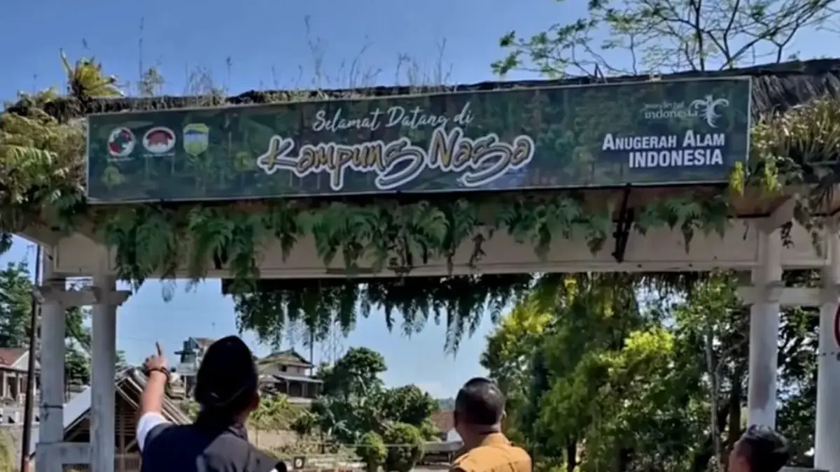 Tampak Gapura dengan spanduk tulisan Selamat Datang di Kampung Naga dengan Kondisi bangunan yang sudah tua.
