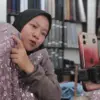 Sintya saat menjelaskan bahan kain ke penonton live streaming di Pasar Kain Cigondewah, Jumat (22/5)