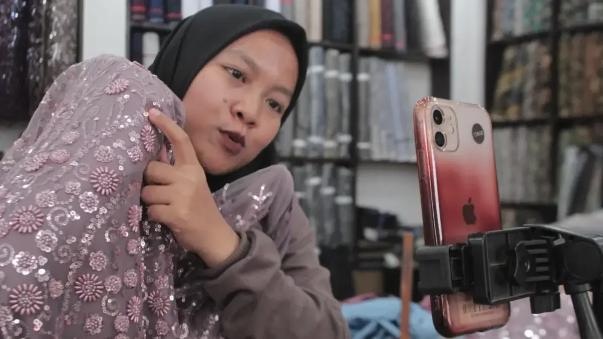 Live Streaming, Nyala Baru Pedagang Pasar Kain Cigondewah di Tengah Sepinya Pembeli Langsung Sintya saat menjelaskan bahan kain ke penonton live streaming di Pasar Kain Cigondewah, Jumat (22/5)