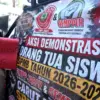 Pengunjuk rasa dari Forum Masyarakat Peduli Pendidikan membawa poster saat berunjuk rasa di Gedung DPRD Jawa B