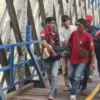 Warga mengevakuasi ODGJ yang nekat berjalan rel kereta api di atas jembatan Cirahong, Senin (16/6/2026).