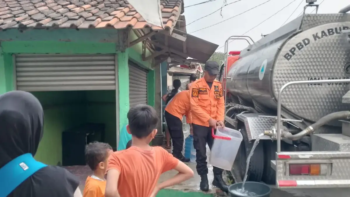 Petugas BPBD Kabupaten Bogor saat menyalurkan bantuan air bersih kepada warga yang terdampak kekeringan. FOTO: