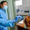 Petugas mengambil sampel dahak seorang pasien saat pemeriksaan deteksi dini superflu di Puskesmas Padasuka