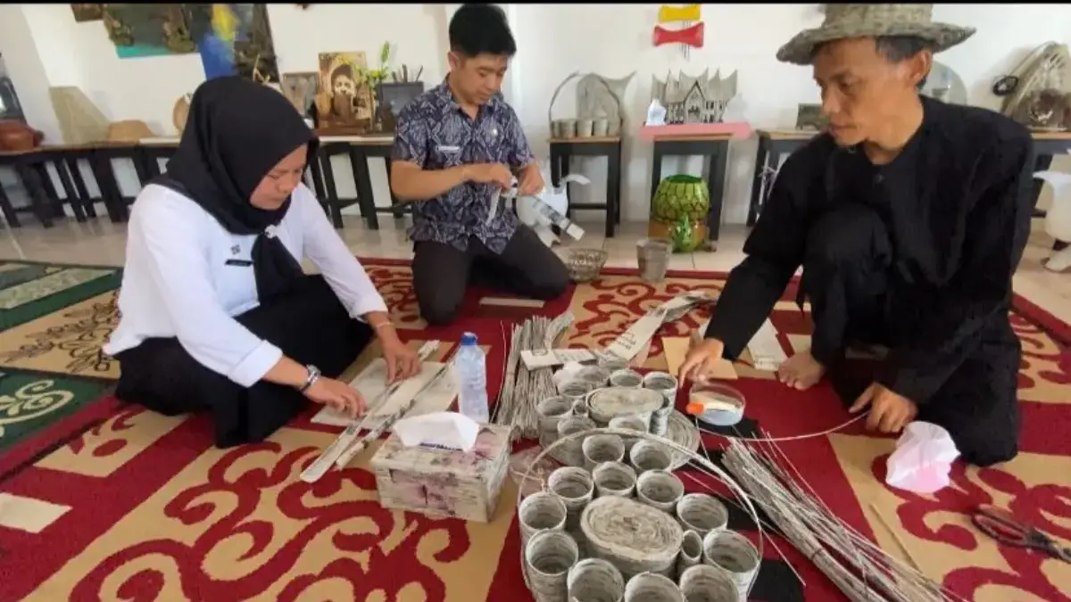 Asep Sopandi (kanan), warga Bojonghuni, berhasil mengubah limbah kertas menjadi berbagai produk kerajinan arti