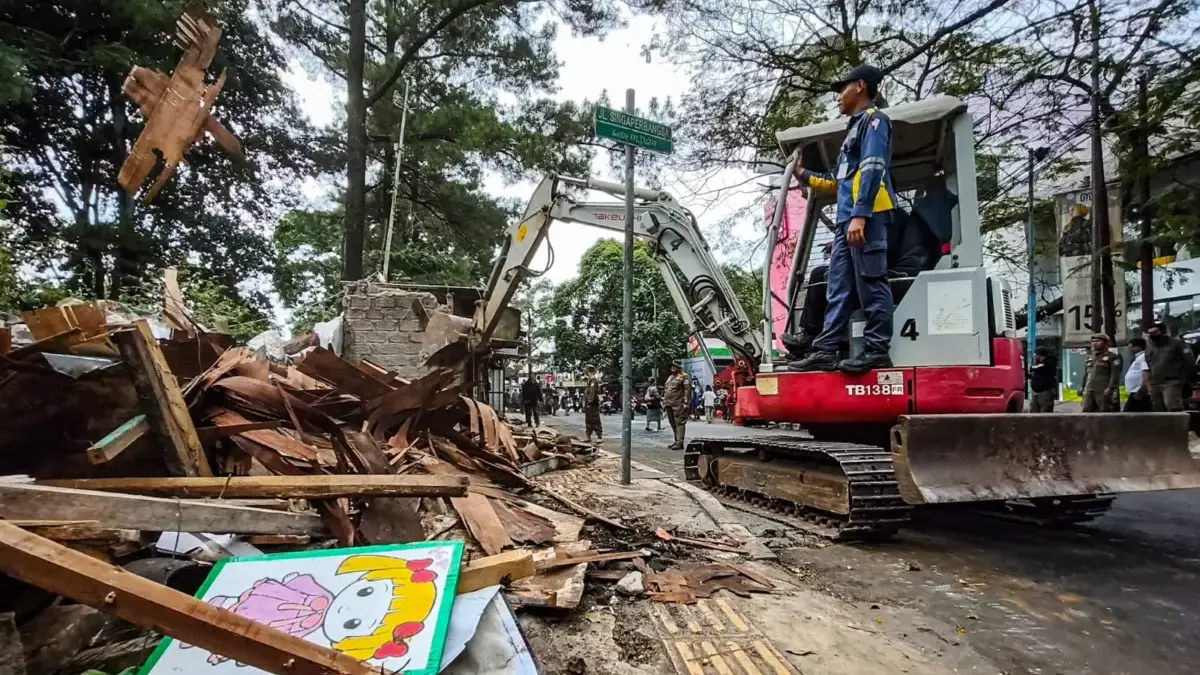 Petugas mengoperasikan alat berat saat penertiban kios bangunan liar di Jalan Singaperbangsa, Kota Bandung, Ra