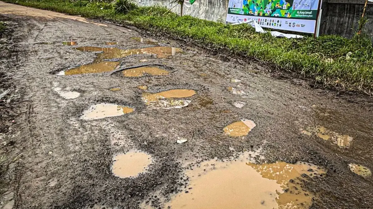 Lubang besar yang tertutup air hujan terlihat di ruas Jalan Rancapanggung-Cikadu, Kecamatan Cililin, Bandung B