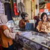 Pekerja melayani calon pembeli seragam sekolah di Jalan Ahmad Yani, Kota Bandung, Rabu (8/7/2026). Pemilik tok