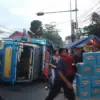 Truk Bermuatan Ratusan Karton Air Mineral Terguling di Jatinangor, Sopir: Jalanannya Miring