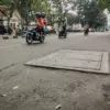 Pengendara sepeda motor melintas di samping proyek manhole galian kabel di Jalan Gatot Subroto, Kota Bandung,