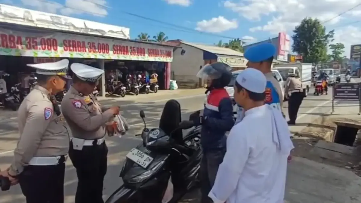 Aris, pengendara saat diberi apresiasi berupa teh manis karena berkendara dengan dilengkapi surat kendaraan be