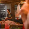 Pedagang melayani pembeli daging ayam ras di Pasar Kosambi, Kota Bandung, Kamis (9/7/2026). Harga daging ayam