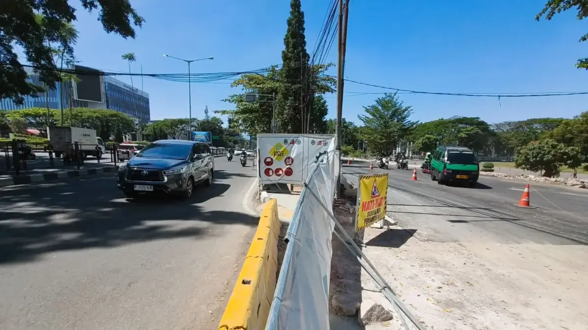 Kendaraan melintas disamping proyek penataan halaman Gedung Sate dan kawasan Gasibu di Jalan Surapati