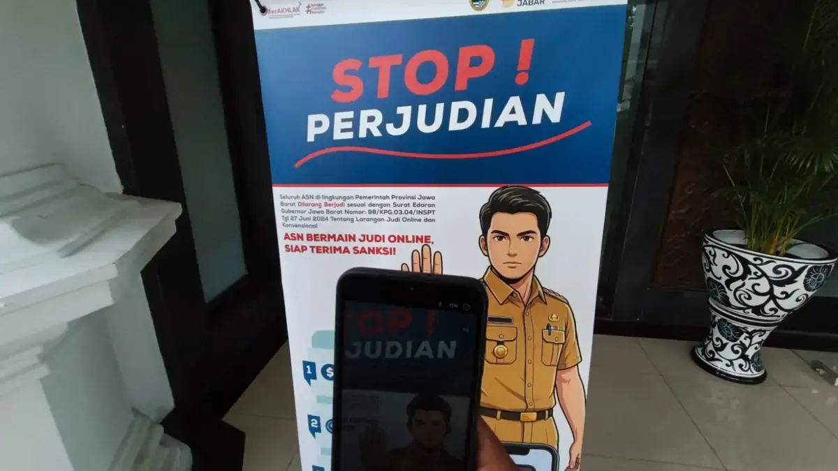 Ilustrasi: Seorang warga memotret spanduk stop perjudian di Jawa Barat. Foto: Dimas Rachmatsyah / Jabar Ekspre