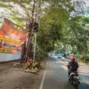Pengendara sepeda motor melintas di samping spanduk peringatan aksi kriminalitas yang terpasang di Jalan Pasir