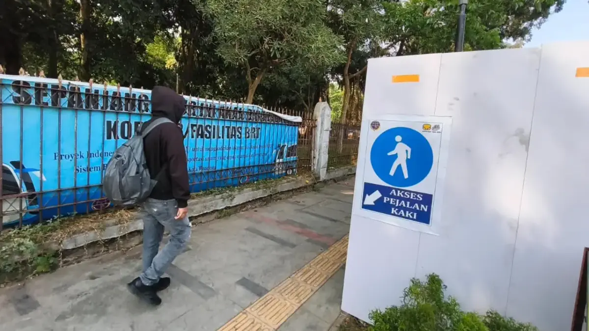 Warga berjalan di samping proyek Bandung Rapid Transit (BRT) di Jalan Otto Iskandar Dinata, Kota Bandung. Foto