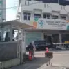 Tampak mesin parkir berwarna oren terpasang di depan gerbang masuk Rumah Sakit Umum Harapan Keluarga yang berl