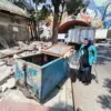 Pedagang kaki lima (PKL) berjalan di samping sisa pembongkaran lapak miliknya usai penertiban di Jalan Ibrahim