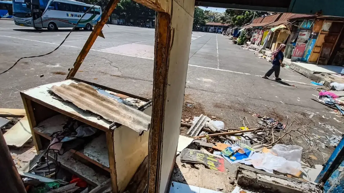 Wajah Baru Terminal Cicaheum, Kios Pedagang Dibongkar untuk Proyek Depo BRT Pedagang berjalan di samping reruntuhan kios miliknya di Terminal Cicaheum, Kota Bandung, Selasa (25/8/2026).