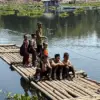 Sejumlah anak sekolah menyeberangi Waduk Saguling menggunakan rakit bambu di Kampung Sadang, Desa Budiharja, K