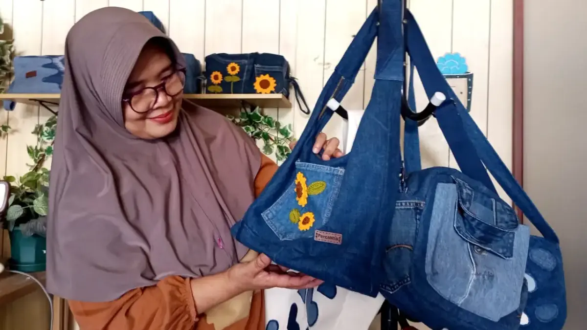 Dari Perca Denim, Nining Merangkai Rupiah UNIK : Nining Idaningsih saat merangkai dan menunjukkan Tas dari perca denim kreasinya. (Hendrik/JE)
