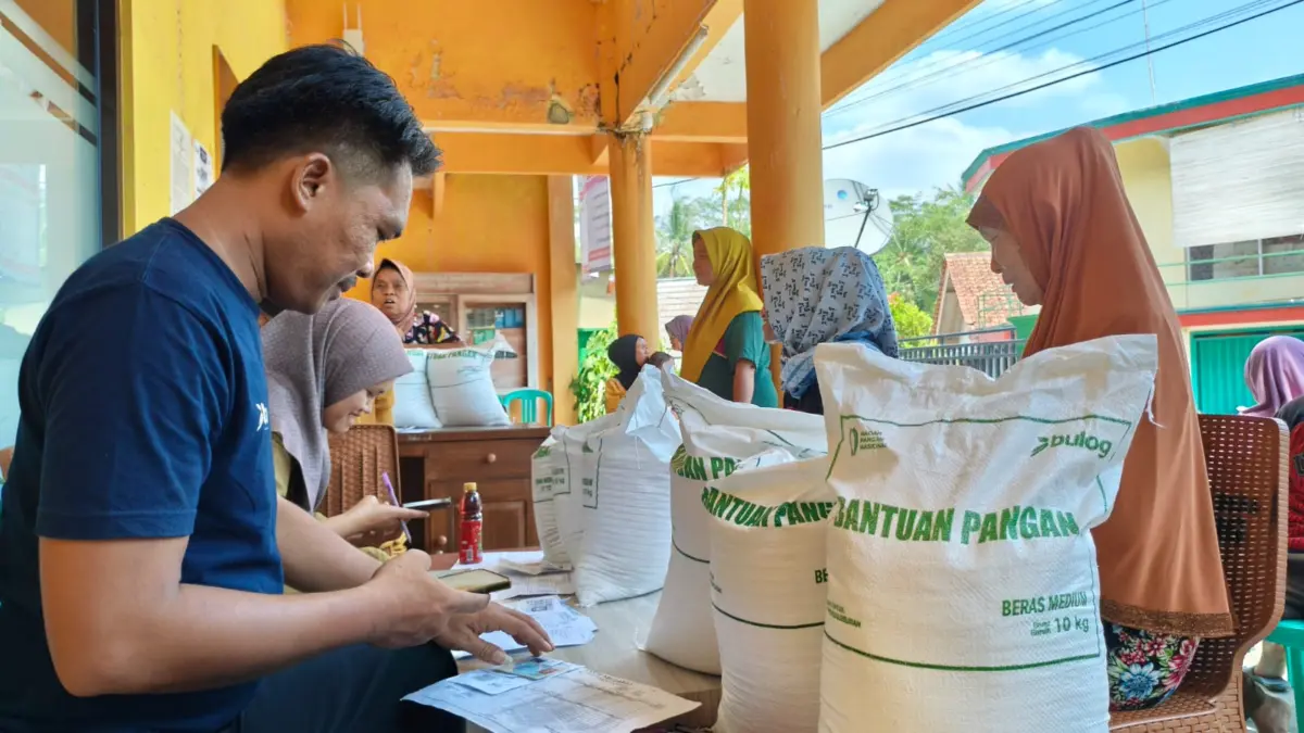 Kasi Pelayanan Desa Cidolog, Yandri Mulyana, saat melayani penerima manfaat Bantuan Pangan di halaman