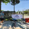 Warga beraktivitas di trotoar di samping spanduk informasi penutupan kawasan Lapangan Gasibu, Kota Bandung, Ra