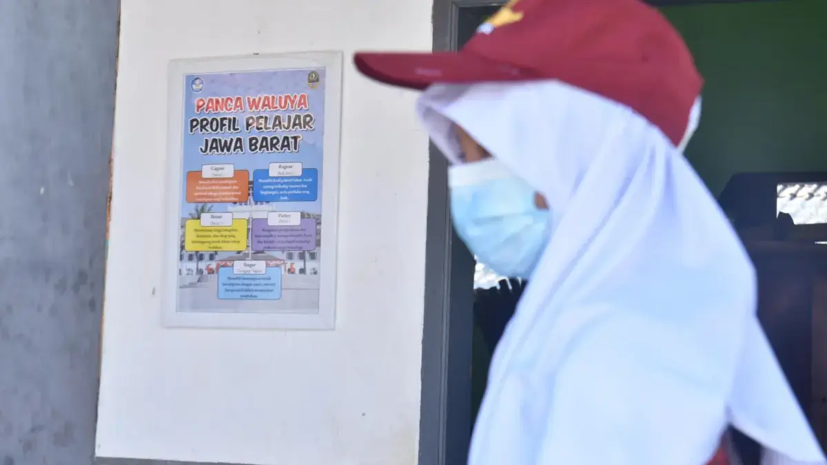 Ilustrasi: Pelajar berjalan di samping poster pancawaluya di Bandung belum lama ini. Foto: Dimas Rachmatsyah /