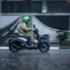 Warga menggunakan sepeda motor melintas saat hujan mengguyur Kota Bandung, Minggu (27/9/2026). BMKG memprakir