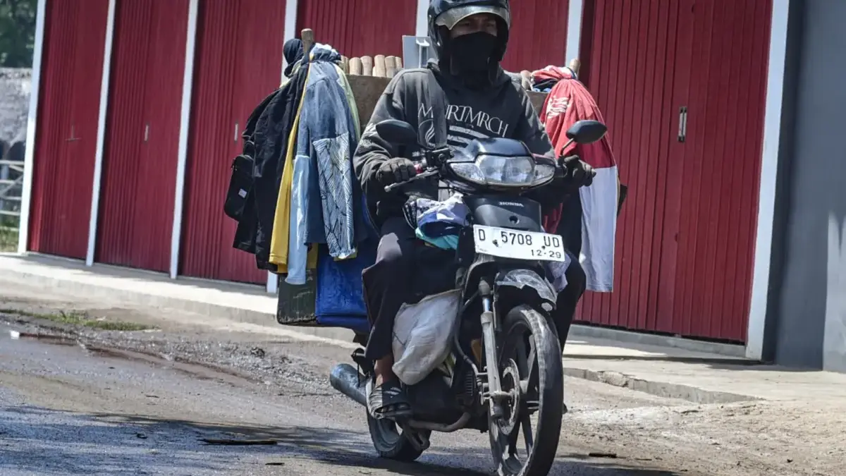 Pengendara sepeda motor menggunakan masker untuk mengurangi dampak abu vulkanik di Bandung, Selasa (8/9/2026).