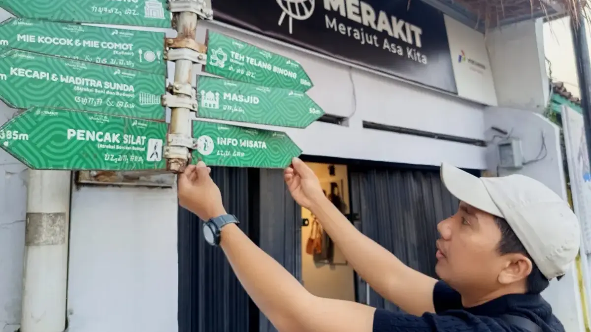 Merajut Wisata Ramah Muslim dari Kampung Binong BERSOLEK : Eka Rahmat Jaya menunjukkan beberapa penunjuk arah di Kampung Rajut Binong. (Hendrik/JE)
