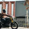 Warga menggunakan sepeda motor melintas di samping pohon yang mengering saat musim kemarau di Jalan LL.R.E. Ma