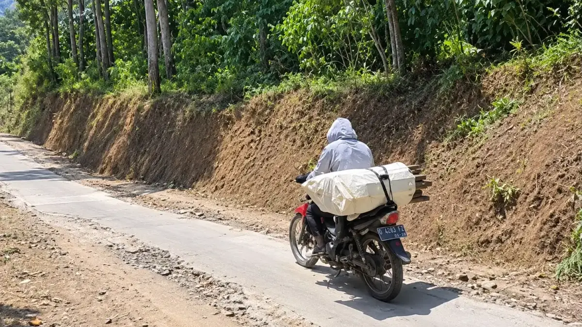 Seorang pengendara motor saat melintasi Jalan Mukapayung-Kidangpanjungan-Tanjungwangi yang menghubungkan Kecam