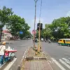 Pedagang cincau menyeberang jalan di samping Alat Pemberi Isyarat Lalu Lintas (APILL) yang tidak berfungsi di